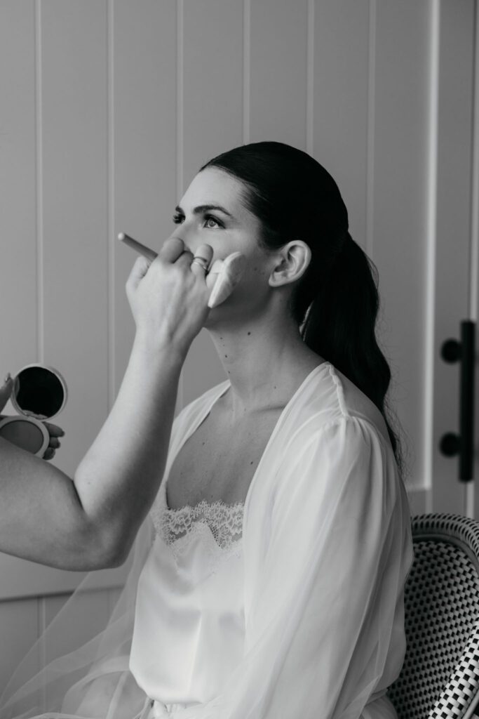 bride getting makeup done in indoor photo studio Long Island