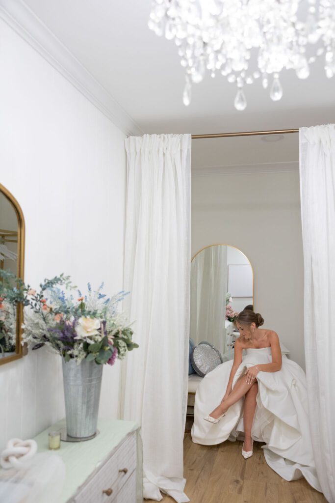 bride putting heels on in private dressing room in wedding getting ready location long island